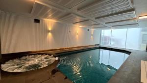an indoor swimming pool in a building with a large pool at Alpine Heights 9 in Mount Hotham