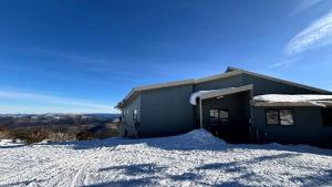 a building with snow on the ground in front of it at Alpine Heights 04 in Mount Hotham