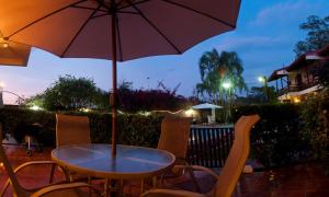 a table and chairs with an umbrella on a patio at Rio Copey 2 near the beach in Jaco in Jacó