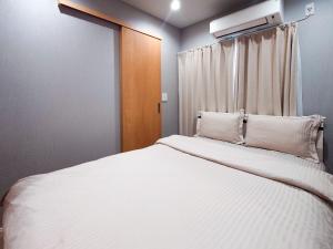 a bedroom with a bed with white sheets and a window at Hotel Yado SK Shinkoiwa - Vacation STAY 17432v in Tokyo