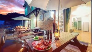 a table with a plate of food on a patio at Gangneung Booyeon Pension in Gangneung