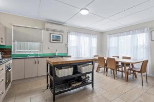 une cuisine et une salle à manger avec une table et des chaises dans l'établissement Silver Myrtle Shack - Aldinga Beach - C21 SouthCoast Holidays, à Aldinga Beach