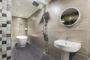 a bathroom with a sink and a shower and a mirror at Yeongju Case Hotel in Yeongju