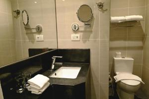 a bathroom with a sink and a toilet and mirrors at Resort-style Comfort Near Mactan Airport in Punta Engaño