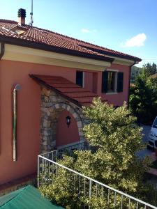 una pequeña casa con una valla delante de ella en Il Ghiretto Appartamento, en Riccò del Golfo di Spezia