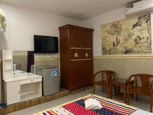 a room with a television and a table with chairs at Duc Long Airport Hotel in Ho Chi Minh City
