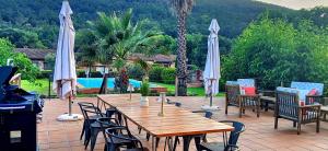 a wooden table and chairs with umbrellas on a patio at La Ermita de los Llanos in Arenas de San Pedro