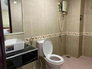 a bathroom with a toilet and a sink at Duc Long Airport Hotel in Ho Chi Minh City +7 photos