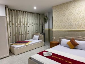 two beds in a room with two beds sidx sidx sidx at Duc Long Airport Hotel in Ho Chi Minh City