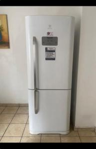 a white refrigerator freezer sitting in a kitchen at Pousada 714 in Brasilia