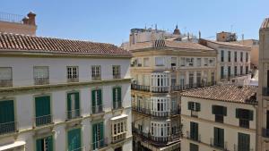 a group of buildings with green windows and roofs at Felix Saenz Boutiques Suites by Del Parque Flats in Málaga