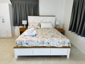 une chambre avec un lit avec deux serviettes dessus dans l'établissement River of Gold Motel, à Cooktown