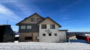 a house with a sign on it in the snow at Alpine Haven 4 in Mount Hotham
