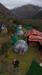 three people standing in front of a group of tents at Salkantay starcamp in Anta