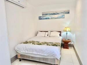 una camera da letto con un letto in una stanza bianca di 云夕民宿 a Nadi