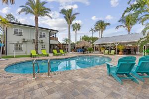 una piscina con sedie blu e palme di Coconut Grove Resort Oasis a Clearwater Beach