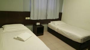 Un pat sau paturi într-o cameră la Tiong Nam Hotel