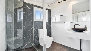 a bathroom with a shower and a toilet and a sink at The Loft in Culburra Beach