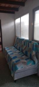 een bed in een kamer met twee ramen bij Ale Rivero in Salta