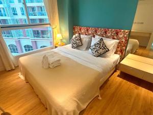 a bedroom with a large bed with a large window at Caribbean Water Park Hotel in Pattaya South
