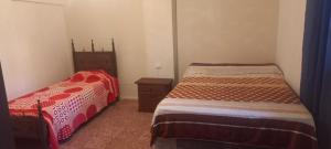 een slaapkamer met 2 bedden en een dressoir. bij Ale Rivero in Salta