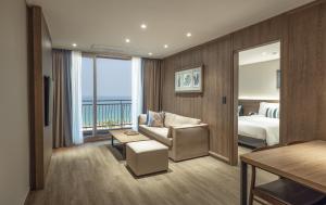 a hotel room with a bedroom and a bed and a couch at Kensington Resort Seorak Beach in Sokcho