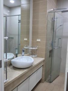 a bathroom with two sinks and a glass shower at Camellia Serviced Suites in Kuala Lumpur
