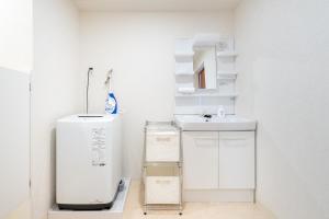 a white bathroom with a sink and a mirror at -Park Higashiueno301- 4-minute walk from Ueno Station in Tokyo