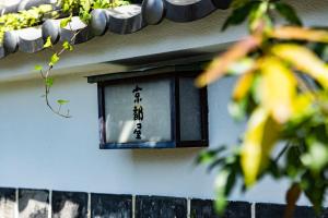 a lantern on the side of a building with writing on it at Kyotoya in Takeo