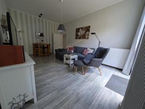 a living room with a couch and a chair at "Villa am NOK" in Rendsburg