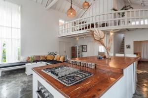a kitchen with a stove top in a living room at European-Inspired Villa Near Beach & Dining in Gili Trawangan