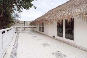 a house with a thatched roof and a patio at European-Inspired Villa Near Beach & Dining in Gili Trawangan