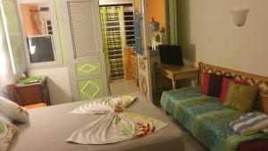 a living room with a bed and a couch at Studio à 5 min à pied de la mer in Sainte-Anne