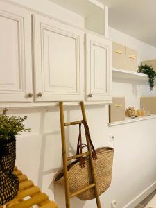 una cocina con armarios blancos y una cesta en Chez gaillard petit studio sans cuisine entièrement rénové au calme, en Ussel