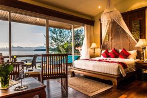 ein Schlafzimmer mit einem Bett mit Blick auf das Meer in der Unterkunft Layalina Hotel in Kamala Beach