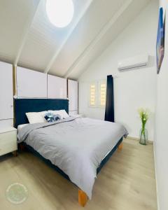 a bedroom with a large bed with a blue headboard at Bungalow Carioca in Le Robert