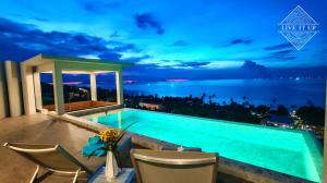 una piscina con vista sull'oceano di notte di Santi Vista Villas a Ko Samui