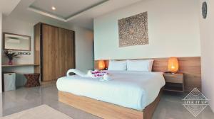 una camera da letto con un grande letto e un animale di peluche di Santi Vista Villas a Ko Samui Altre 62 foto