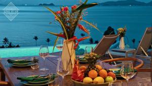 un tavolo con un cesto di frutta e un vaso di fiori di Santi Vista Villas a Ko Samui