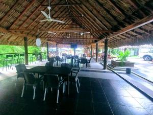 a restaurant with tables and chairs and a ceiling at Hotel Campestre la Meseta in Puerto Boyacá