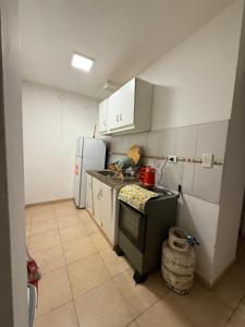 a kitchen with a stove and a refrigerator at Apartamento en ZONA CÉNTRICA Resistencia in Resistencia