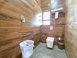 a bathroom with a toilet and wooden walls at City Service Apartment in Chikmagalūr +22 photos