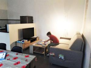 een man op een tafel in een woonkamer bij L'appart Millau Centre-Ville - Gite in Millau