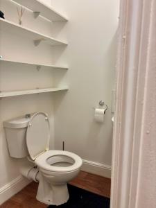 バーミンガムにあるDeluxe Suite Aのバスルーム(白いトイレ、棚付)