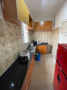a kitchen with wooden cabinets and a black counter top at 2 bedroom terrace in Lekki