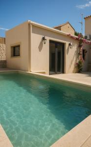 a house with a swimming pool in front of a house at Village Escape House by CorfuEscapes in Lefkimmi