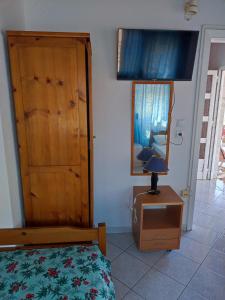 a bedroom with a bed and a dresser with a lamp at Sunray Studios Asprovalta in Asprovalta