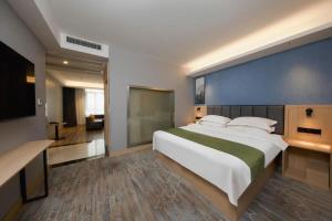 a large bedroom with a large bed with a blue wall at GreenTree Inn Jiangsu Changzhou Henglin Town Shuntong Road Express Hotel in Changzhou +239 photos