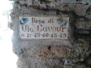 a sign on the side of a stone wall at Casa Sulla Rupe in Calcata +50 photos