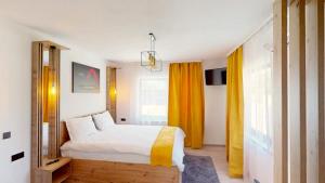 1 dormitorio con cama y cortina amarilla en D&M Family Residence Bran 2, en Bran